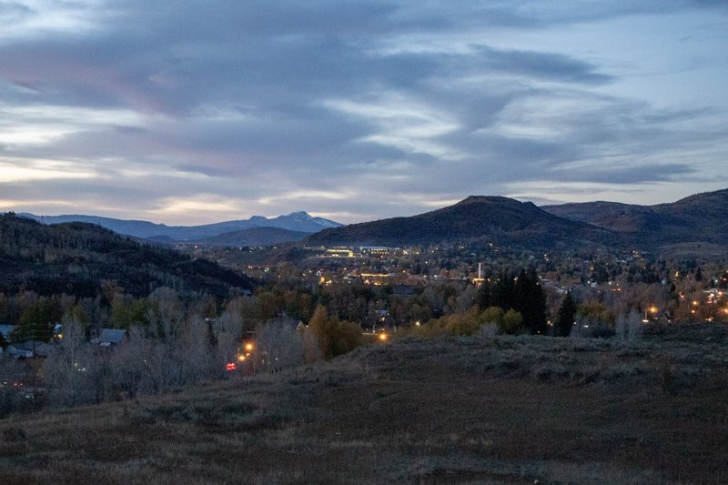 Town lights in a valley under dramatic dusk clouds