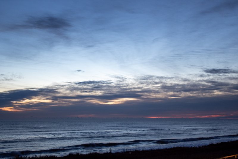 Blue-hour ocean horizon with a thin pink glow