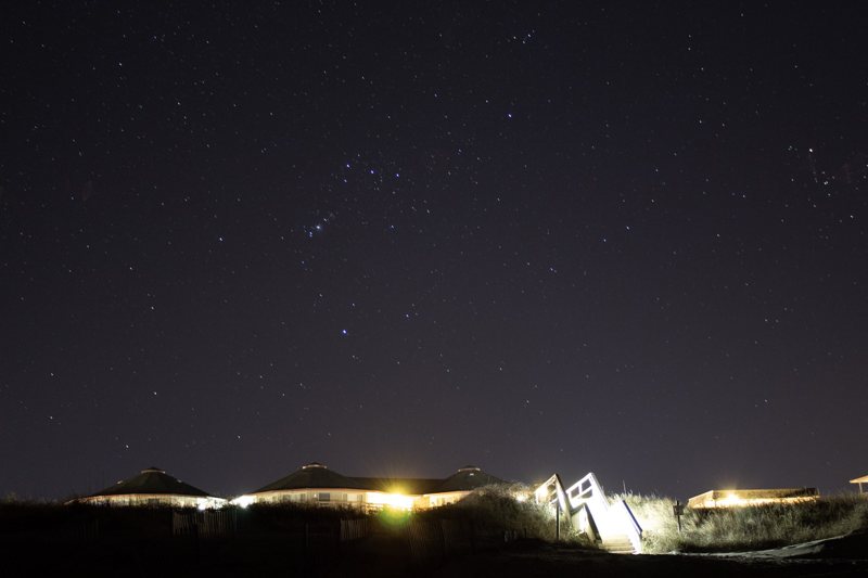 Starry sky over distant lights on the horizon