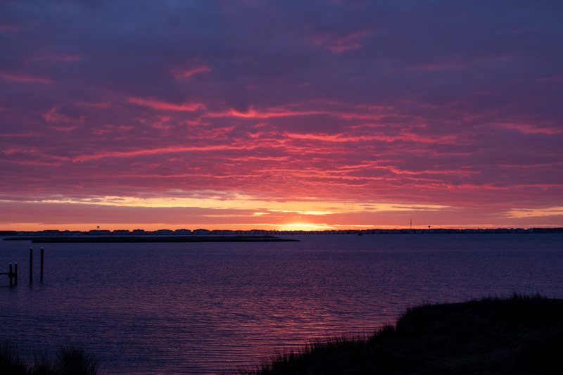 Vivid pink sky reflected on still water